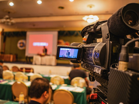 Close up Professional Video Camera in conference hall or seminar room with attendee...