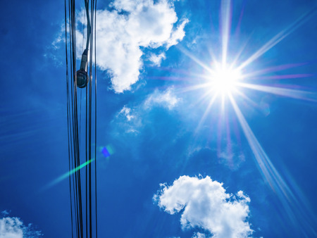 Idyllic blue sky and sun ray with City electronic wire in the cityの写真素材