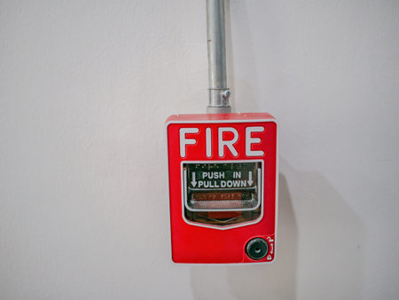 Fire alarm on white wall texture background