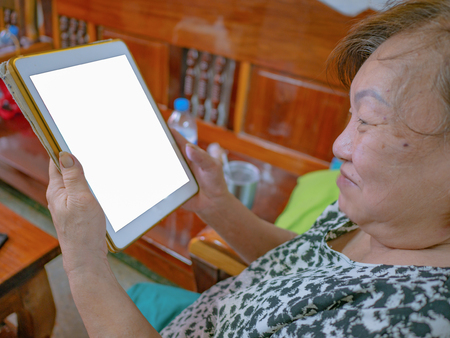 Old asian women very happy Look at the tablet,Mock upの写真素材