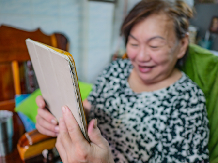 Very happy Old asian women Look at the tablet in her house,Old cutie womenの写真素材