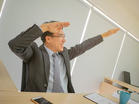 Very Happy asian business man sitting on his desk,business conceptの写真素材