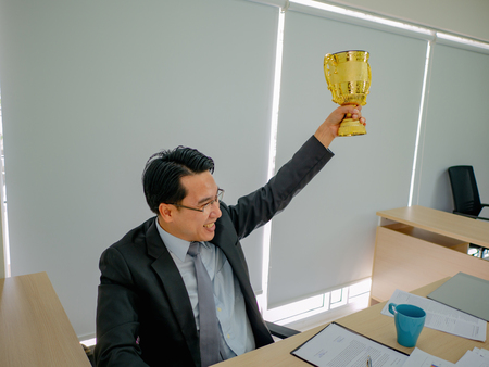 Asian Business man get the golden trophy,business concept
の写真素材