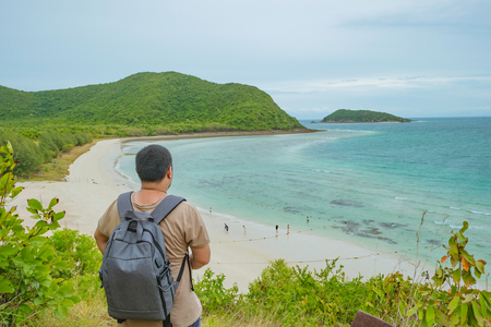 Asian fatty backpacker stand on view point on top of the island with idyllice beach ocean and blue sky in vacation time,Samae San Island chonburi thailand,summer conceptの写真素材