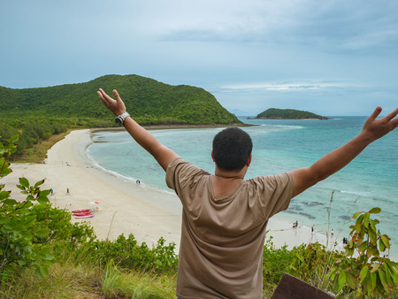 Asian fatty backpacker stand on view point on top of the island with idyllice beach ocean and blue sky in vacation time,Samae San Island chonburi thailand,summer conceptの写真素材