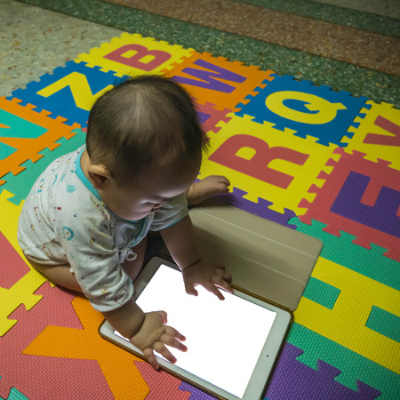 Cutie Asian Boy baby try to use Tabletの写真素材