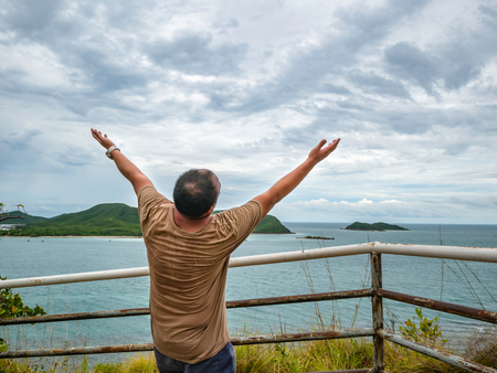 Asian Fat traveler stand on viewpoint with tropical idyllic ocean  and white cloud sky in vacation time,Chonburi thailand,Holiday conceptの写真素材