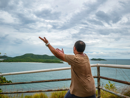 Asian Fat traveler stand on viewpoint with tropical idyllic ocean  and white cloud sky in vacation time,Chonburi thailand,Holiday conceptの写真素材