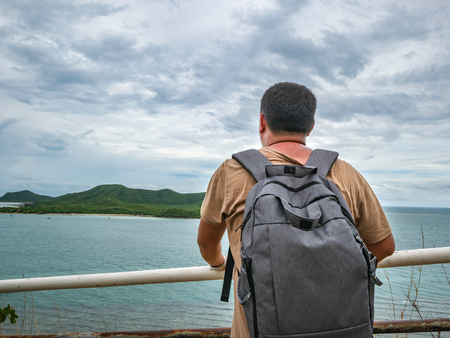 Asian Fat Backpacker stand on viewpoint with tropical idyllic ocean  and white cloud sky in vacation time,Chonburi thailand,Holiday conceptの写真素材