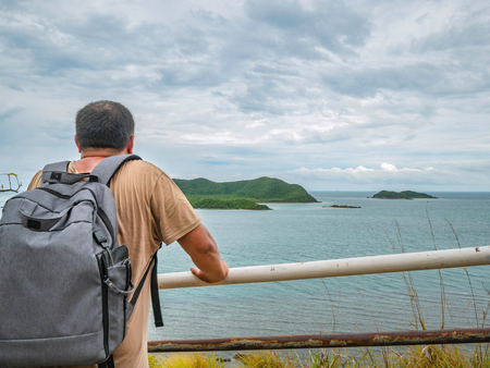 Asian Fat Backpacker stand on viewpoint with tropical idyllic ocean  and white cloud sky in vacation time,Chonburi thailand,Holiday conceptの写真素材