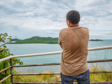 Asian Fat traveler stand on viewpoint with tropical idyllic ocean  and white cloud sky in vacation time,Chonburi thailand,Holiday conceptの写真素材