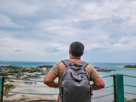 Asisn Fat Backpacker stand on top of  Khao Ma Jor Pier  with Idyllic ocean beautiful white cloud endless horizon and Fishman townscape in vacation time,chonburi thailand,holiday conceptの写真素材