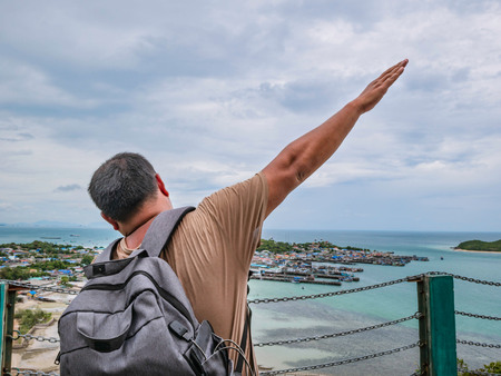 Asisn Fat Backpacker stand on top of  Khao Ma Jor Pier  with Idyllic ocean beautiful white cloud endless horizon and Fishman townscape in vacation time,chonburi thailand,holiday conceptの写真素材