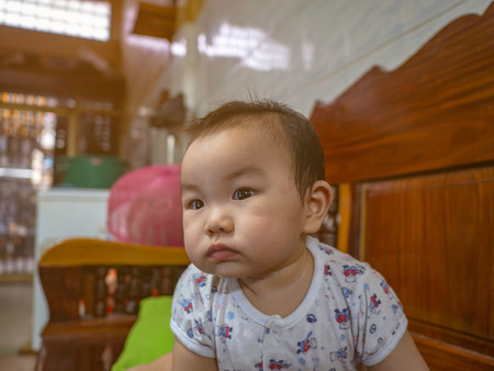 Cutie and handsome asian boy baby or infant make a face like interested with somethingの写真素材