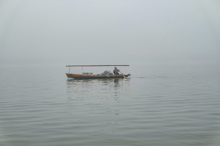 One Boat on beautfiul Xihu lake(West Lake) one of destination in china with foggy or mist in winter season,hangzhou chinaの写真素材