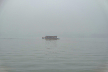 One Boat on scenic Xihu lake(West Lake) with foggy or mist in winter season,hangzhou chinaの写真素材