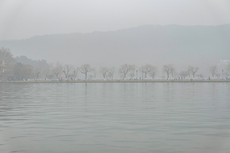 Beautiful Xihu lake(West Lake) with foggy or mist in winter seasonの写真素材