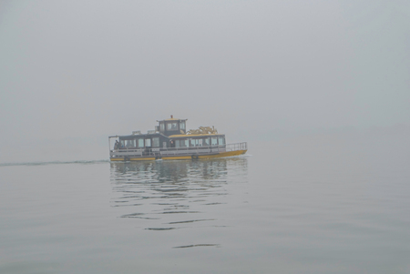 One Boat on scenic Xihu lake(West Lake) with foggy or mist in winter season,hangzhou chinaの写真素材