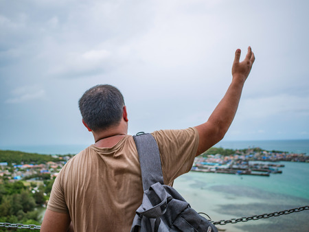 Asisn Fat Backpacker stand on top of  Khao Ma Jor Pier  with Idyllic ocean beautiful white cloud endless horizon and Fishman townscape in vacation time,chonburi thailand,holiday conceptの写真素材