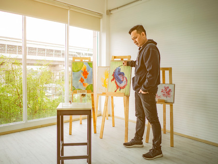 Handsome Young Asian man or water color artist Teaching how to paint in studioの写真素材