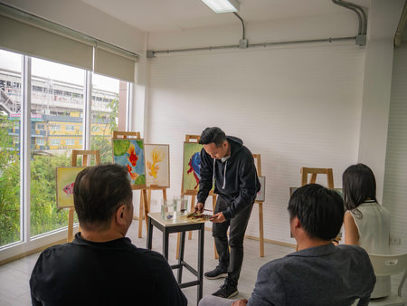 Handsome Young Asian man or water color artist Teaching how to paint in studio,fish conceptの写真素材
