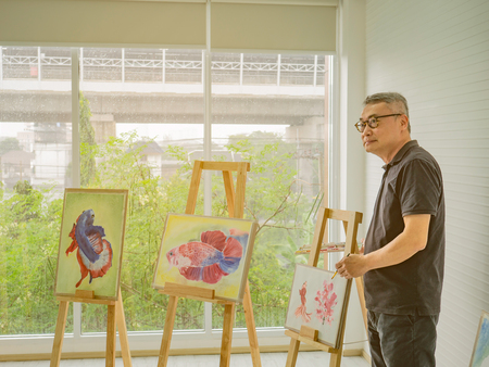 senior adult artist teacher teaching in the class room,fish and art drawing conceptの写真素材