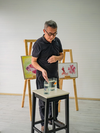 senior adult artist teacher teaching in the class room,fish and art drawing conceptの写真素材