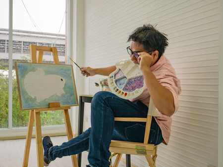 Crazy Young adult Male watercolor artist drawing the fish paint,fish and art conceptの写真素材