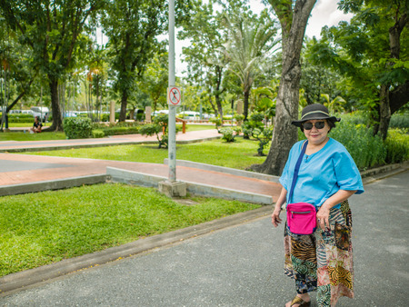 Asian Senior women walking in Chatuchak park Bangkok city Thailandの写真素材