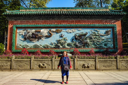 Asian senior women with Two chinese Dragon on the Blue wall in "The Ancestral temple".Foshan city chinaの写真素材