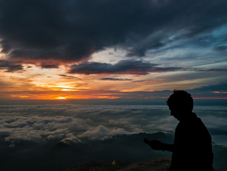 Silhouette People on the cliff with beautiful sunrise sky on Khao Luang mountain in Ramkhamhaeng National Park,Sukhothai province Thailandの写真素材