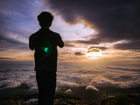 Silhouette People on the cliff with beautiful sunrise sky on Khao Luang mountain in Ramkhamhaeng National Park,Sukhothai province Thailandの写真素材