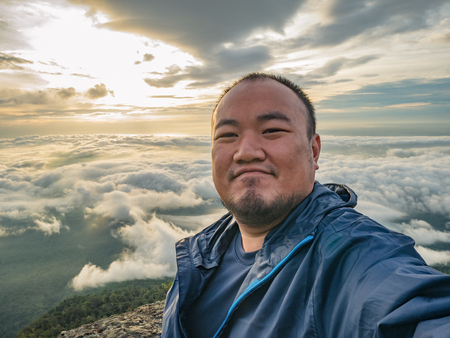 Asian Traveler Take a Selfie with Beautiful Sunrise Sky on the mountainの写真素材