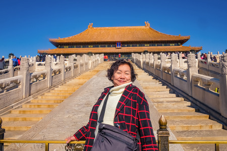 Portrait photo of Senior asian women with "Taihedian" palace in the Forbidden Palace Gate at beijing Capital City of chinaのeditorial素材