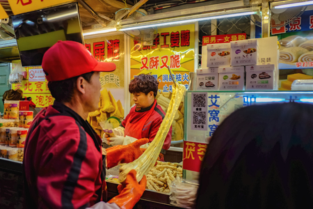 Beijing, China - 25 February 2017: Unacquainted chinese Chef Cooking and Selling local cuisine on wangfujing Walking street in beijing city, China travelのeditorial素材