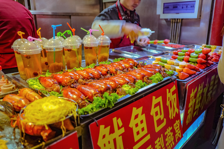 Beijing, China - 25 February 2017: Unacquainted chinese Chef Cooking and Selling local cuisine on wangfujing Walking street in beijing city, China travelのeditorial素材