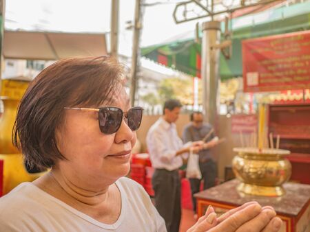 Portrait photo of Senior asian women 
pay respect to god in the Chinese Temple at bangkok City Thailandの写真素材