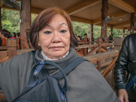 Portrait Senior asian women Wearing the hat on Zhangjiajie National Forest Park in Wulingyuan District Zhangjiajie City China in the Foggy dayのeditorial素材