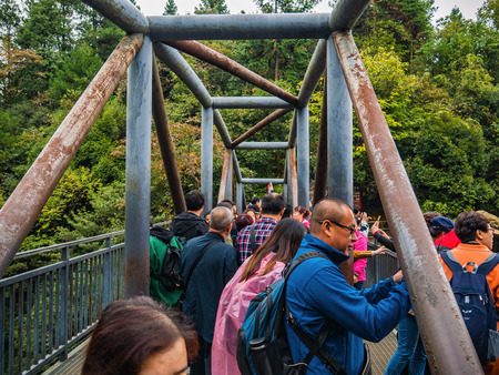 zhangjiajie/China - 14 October 2018: Unacquainted Tourists stand on the bridge on tianzi mountain in Zhangjiajie National Forest Park in Wulingyuan District Zhangjiajie City China in the Foggy day.のeditorial素材