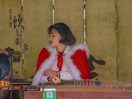 zhangjiajie/China - 15 october 2018:Beautiful Unacquainted traditional women performance Guzheng chinese instrument on tianmen mountain at Zhangjiajie city china.Travel landmark of zhangjiejiaのeditorial素材