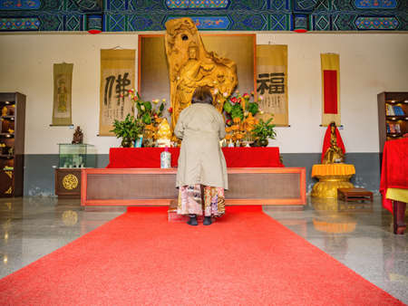 zhangjiajie/China - 15 october 2018:Senior asia women Praying to Goddess of Compassion or Guanyin goddess Statue in Tianmen Temple Hall on tianmen mountain zhangjiajie city Chinaのeditorial素材