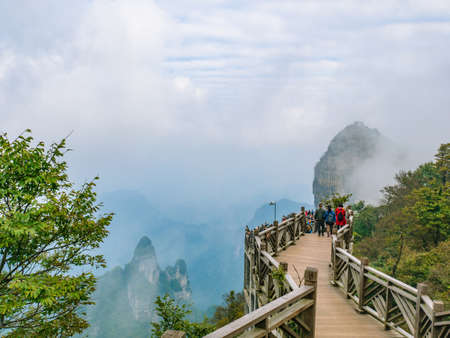 zhangjiajie/China - 15 October 2018:Unacquainted Tourists walking on wooden bridge crossing the mountain on  tianmen mountain national park at Zhangjiajie city china.tianmen mountain the travel landmark of hunan zhangjiajie chinaのeditorial素材