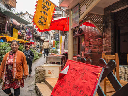 fenghuang,Hunan/China-16 October 2018:Tourist walking in alley building district of Fenghuang ancient town.phoenix ancient town or Fenghuang County is a county of Hunan Province, Chinaのeditorial素材