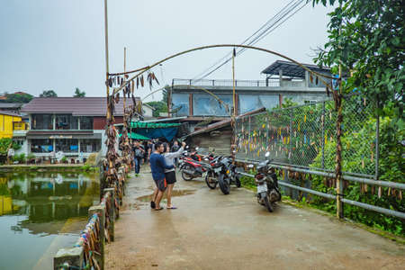 kanchanaburi/Thailand-1 July 2017:Unacquainted People walking on the bridge at Etong village the hidden village in the mist at kanchanaburi city Thailand.praying tag on the bridge.Pilok mine The Old mine near the Thai-Myanmar borderのeditorial素材