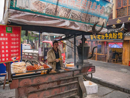fenghuang,Hunan/China-16 October 2018:Unacquainted chinese people Grilling lamb in Fenghuang ancient town.phoenix ancient town or Fenghuang County is a county of Hunan Province, Chinaのeditorial素材