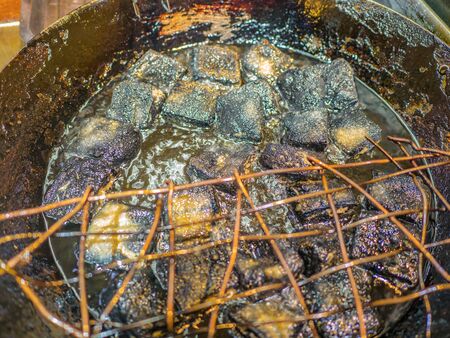 Close up Black stinky tofu Frying in the pan at fenghuang old town China.phoenix ancient town or Fenghuang County is a county of Hunan Province, Chinaの写真素材
