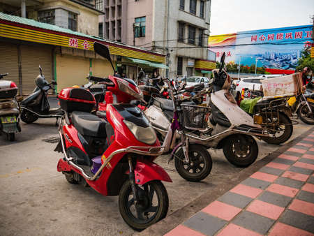 Shantou/china-30 march 2018:Chinese electric motorcycle parked in downtown district at shantou city at china.electric motorcycle is the most famous automobile in chinaのeditorial素材