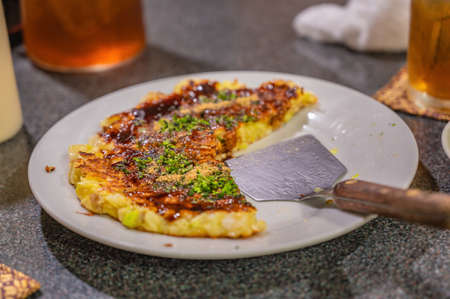 Okonomiyaki traditional Japanese food in Japanese restaurant.Okonomiyaki as known as traditional japan pizzaの写真素材