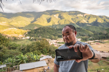 Asian fat traveler selfie himself with beautiful mountain view of Sapan Village At nan Thailand.Sapan is Small and tranquil Village in the mountain.Thailand destination travelの写真素材