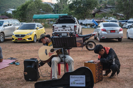 Nan.thailand-18.12.2020:Unacquainted street performance with his guitar at small market in Sapan Village At nan Thailand.Sapan is Small and tranquil Village in the mountain.のeditorial素材